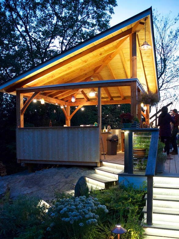Outdoor Kitchen - Open cooking and entertaining spaces, lit for year-round function and ambiance.