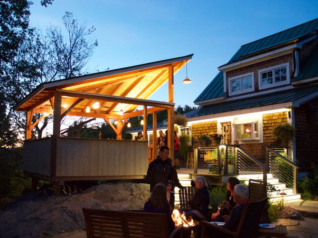 A firepit fronts the kitchen. The stairs and deck beyond are lit with tunable LED tapes.